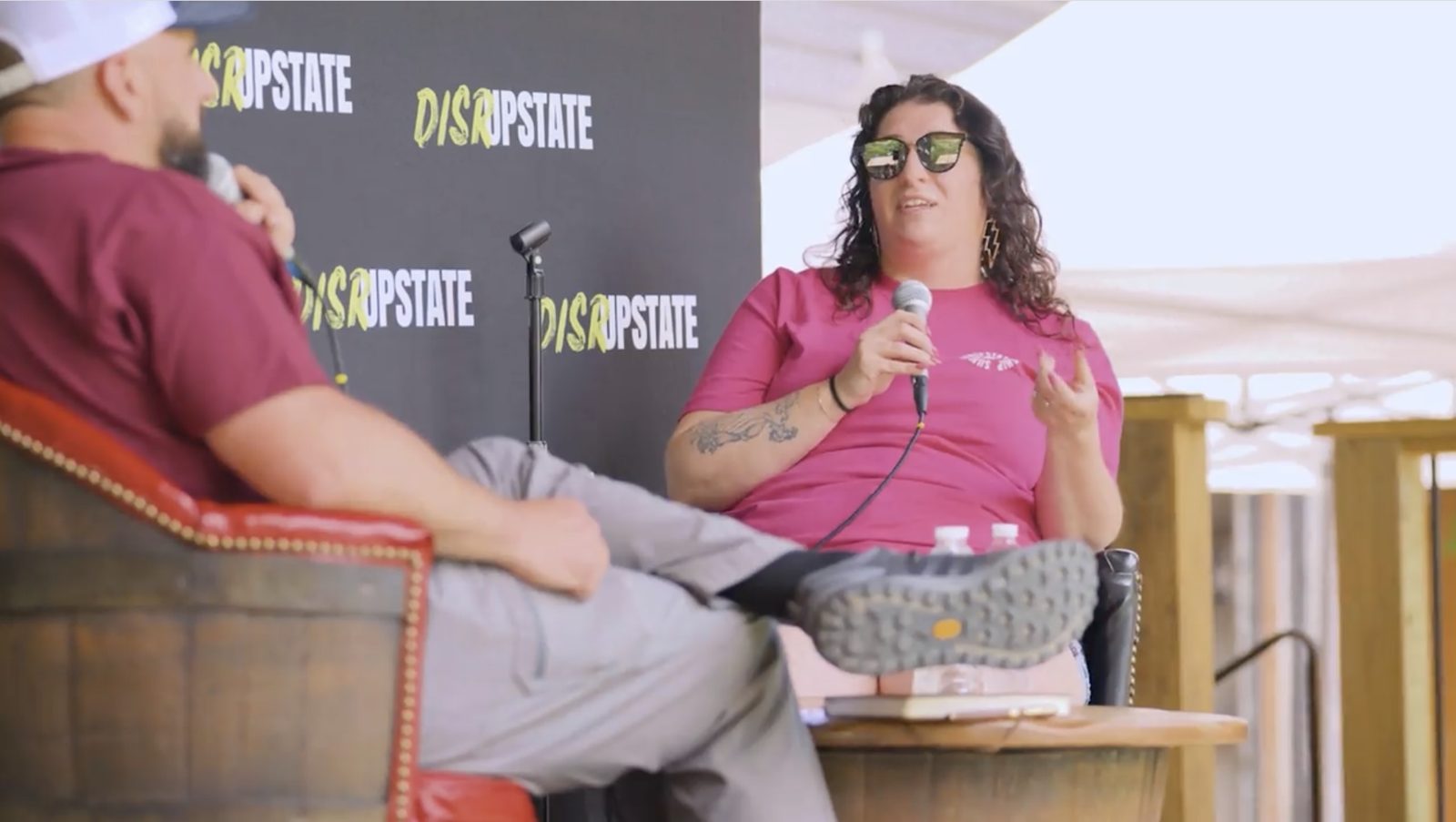 Lindsay Mastro speaking into a microphone during a live podcast at the DisrUpstate Leadership Summit