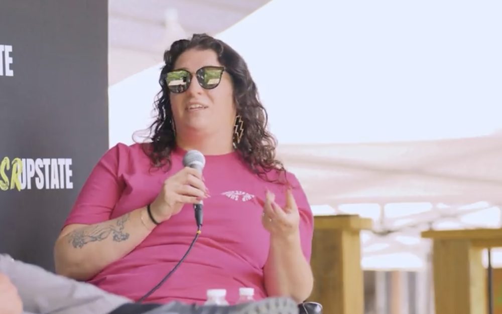 Lindsay Mastro speaking into a microphone during a live podcast recording