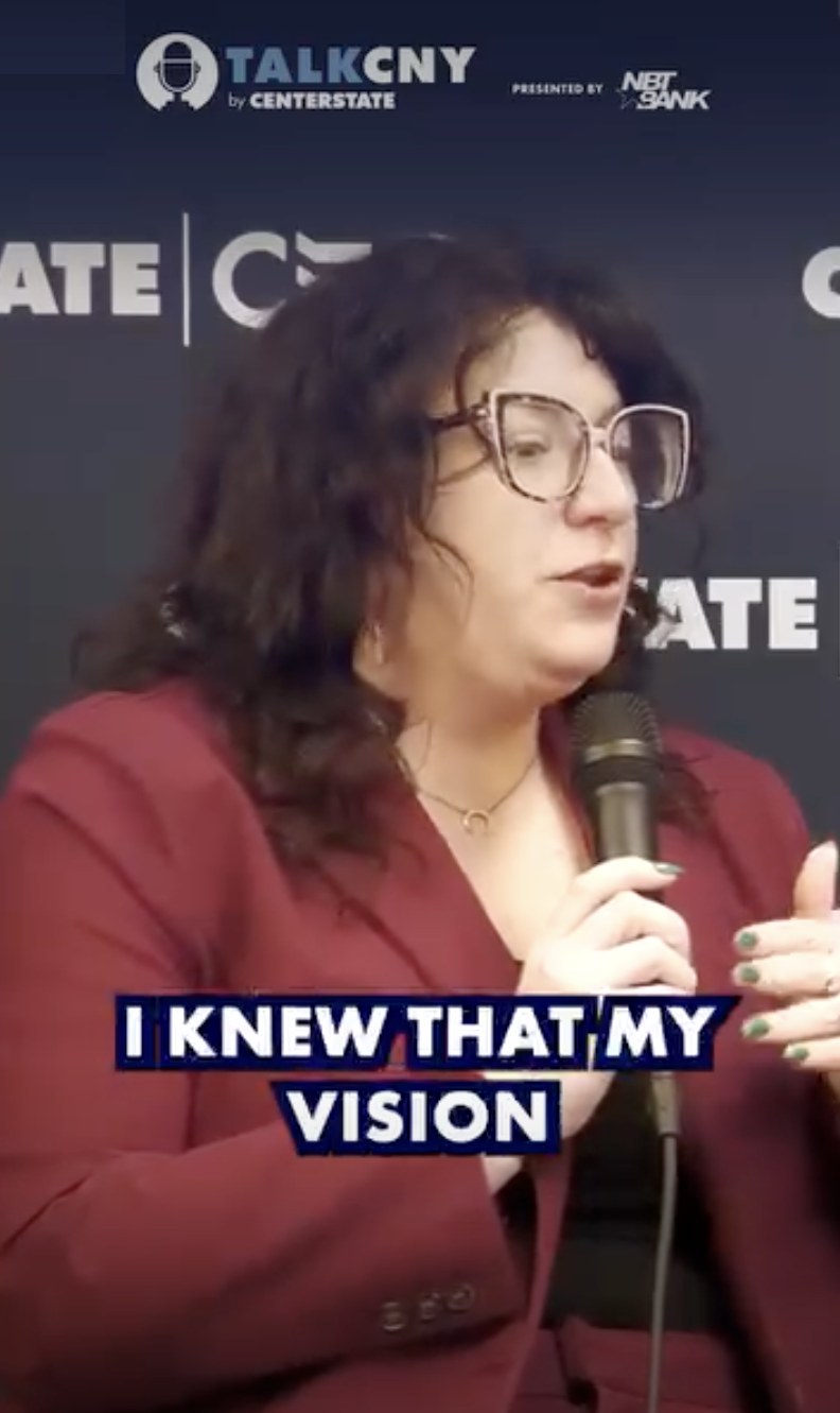 Lindsay Mastro speaking into a microphone on the Talk CNY podcast set